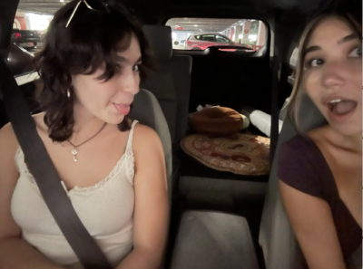 A Selfie of two girls in a car with furniture in the back 